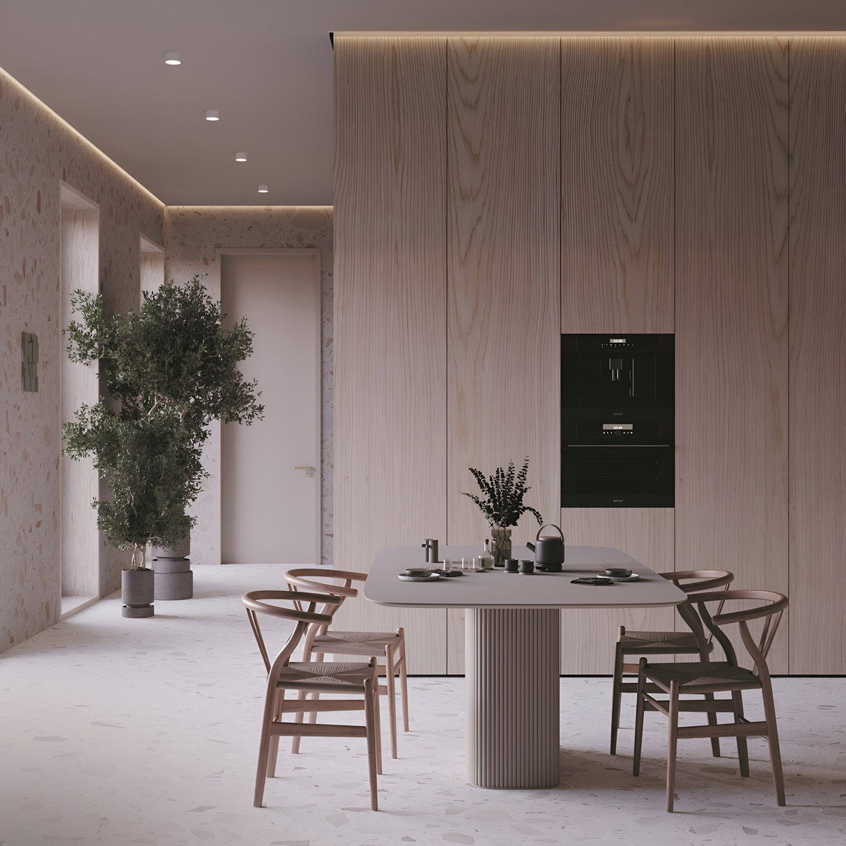 A modern kitchen with minimalist design features a light wood table set with dishes and a teapot, surrounded by four wooden chairs. A leafy plant adds greenery, while energy-efficient Hoop Small Round Surface Downlights - White illuminate the wood-paneled walls and ceiling in this space.