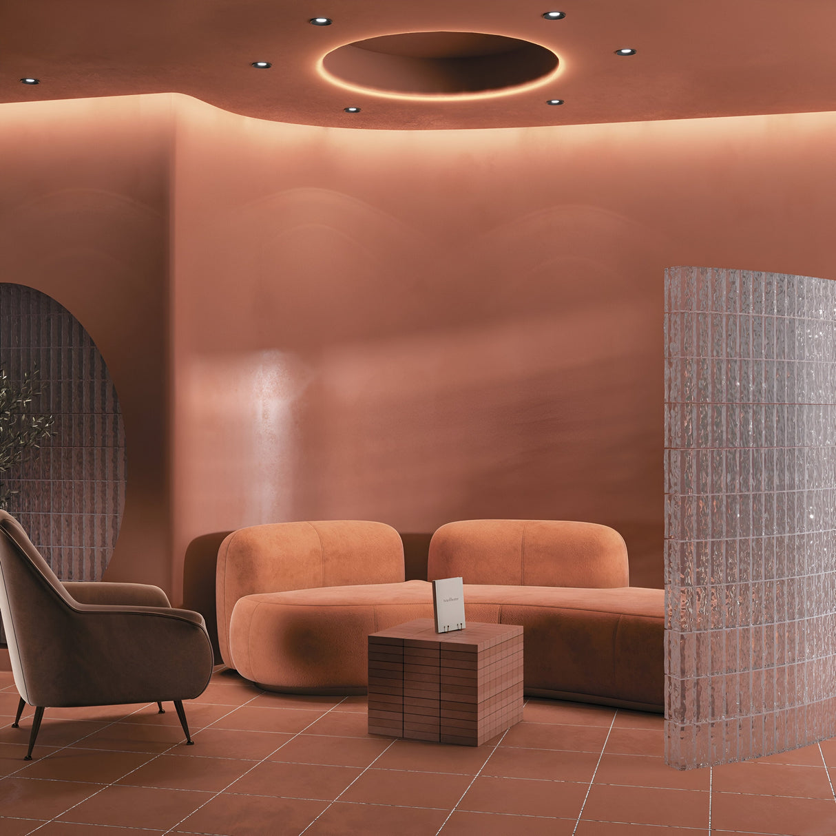 A modern room in warm browns showcases a curved sofa, armchair, and wooden cube table. Illuminated by a Slim Fixed Round Recessed Downlight - Black beneath a circular skylight, it features a transparent textured screen as a stylish partition for minimalist decor.