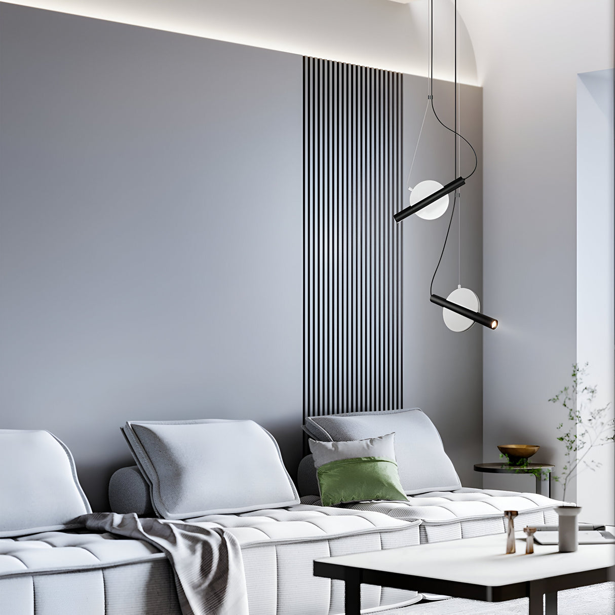 Modern minimalist living room with a light gray sofa accented by a green pillow, illuminated by the Enigma Adjustable LED Pendant Light in white with black. Vertical line accents on the wall, decor items on a small coffee table, and a plant visible to the right complete the setup.