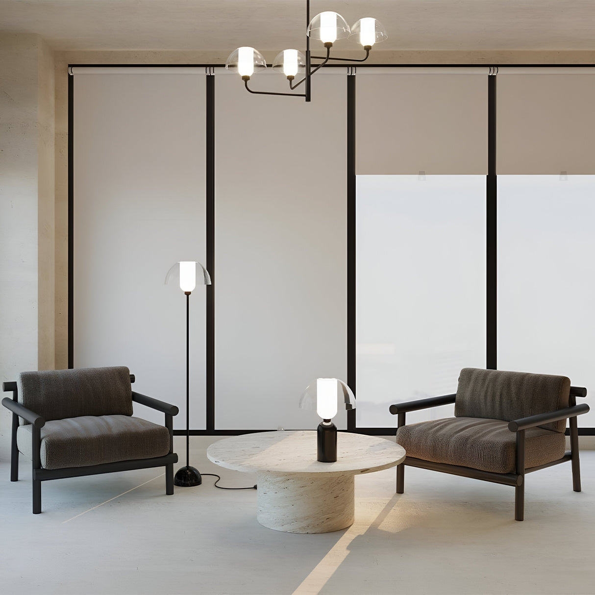 A minimalist living room features two modern armchairs facing a round marble table with a small table lamp. A standing lamp sits beside one chair. Floor-to-ceiling windows have neutral blinds, and the Memory 4 Light Chandelier in black elegantly hangs overhead.