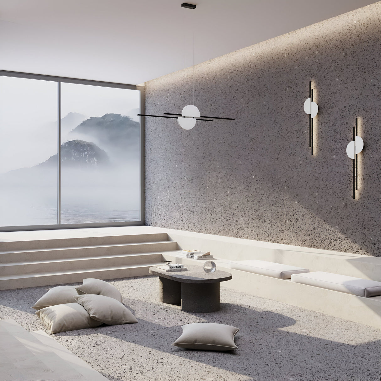 A minimalist living room with a large window offers a misty mountain view. It features a textured gray wall, Skyline LED Linear Suspension Light in black & white with adjustable height, a low black table, white cushions on beige flooring, and stairs leading to the panoramic vista.