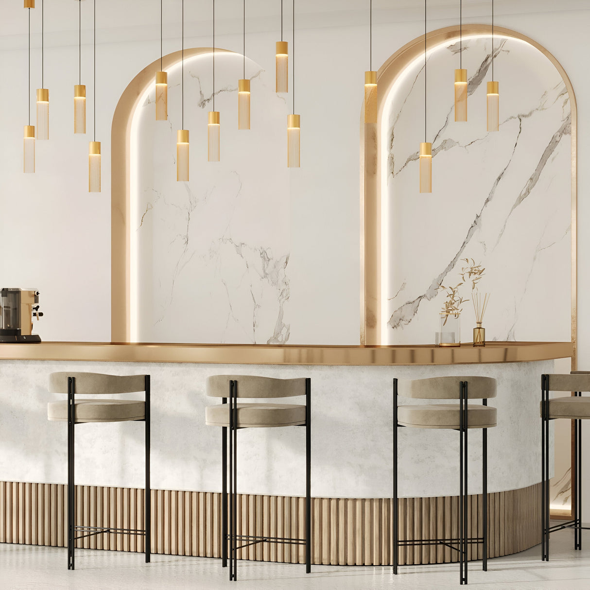 The cafes modern interior features a sleek white marble counter with light wood accents, lined by three high chairs. Elegant Imaginary Chain Pendant Lights in gold hang from the ceiling, while large arched marble wall features are softly backlit.