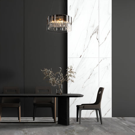 In a modern dining room, a black table is paired with three dark chairs and a decorative vase filled with dried branches. The walls display a black and white marble pattern, while the Wonderland 4 Light Chandelier in gold, adorned with crystal pendants, hangs elegantly above, casting a refined glow.