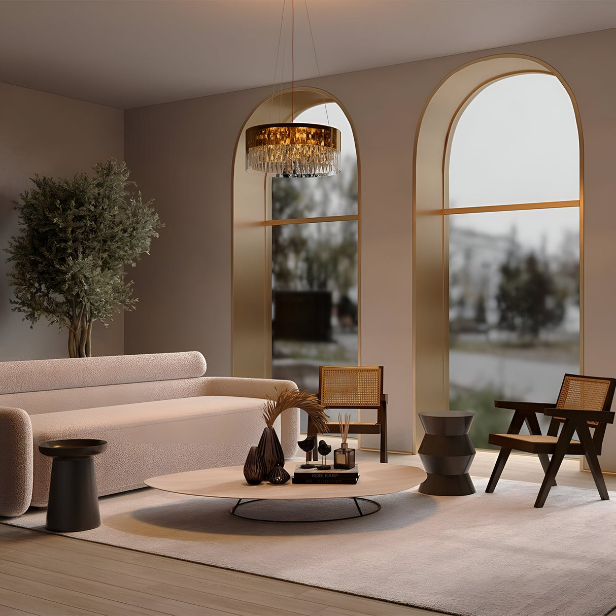 A modern living room showcases a beige sofa, wooden chairs, and a round coffee table. Natural light streams through two large arched windows, while the Wonderland 6 Light Chandelier - Gold with crystal pendants hangs overhead. A plant enhances the minimalist decor with greenery.