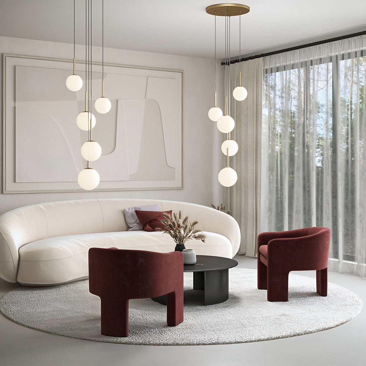 A modern living room with a minimalist design features a white curved sofa, two red velvet chairs, and a round black coffee table. Illuminated by the Basic Form 5 Light Cluster Pendant - White & Gold, frosted opal glass globes enhance sheer curtains and large abstract wall art.