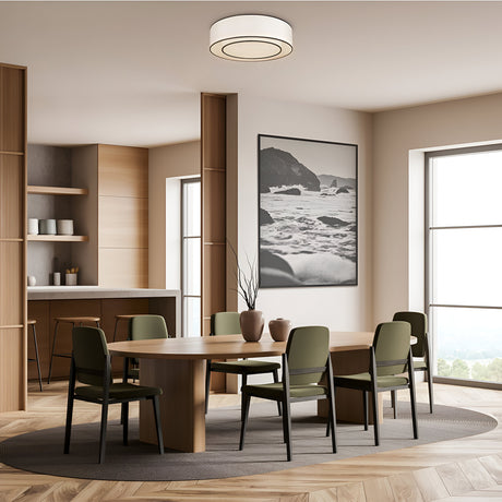 A modern dining room features a wooden table surrounded by six green chairs. A large ocean-themed painting adorns the wall. The space benefits from floor-to-ceiling windows and a shelf with dishes, illuminated by the Bergamo 3 Light Flush. It shares space with the kitchen on the left.