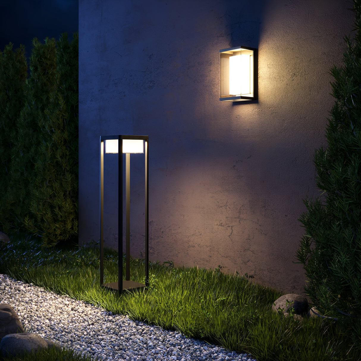 The garden path is lit by modern outdoor lighting, including a Baker Street Outdoor LED Wall Light - Black (O021WL-L10B4K) with an IP65 rating. A square wall-mounted light and tall slender lamp bathe the greenery and gravel walkway in soft glows, bushes beside the concrete wall amplify serenity.