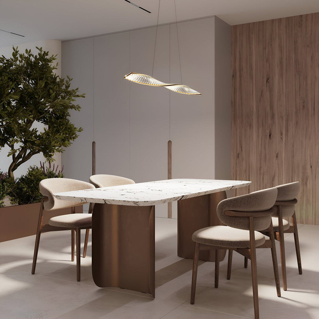 A modern dining room highlights a rectangular marble table with four cushioned chairs under the Krone LED Long Crystal Linear Suspension Light - Brass. The space has a wooden accent wall, neutral tones, minimal brass accents, and a potted plant in the corner.