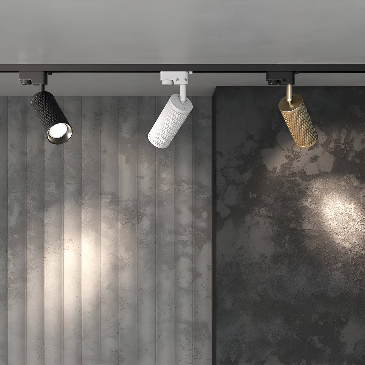 The Unity Track Spotlight Black, with a GU10 base, offers ceiling-mounted lighting with three cylindrical focus beams in black, white, and gold on a textured wall with vertical panels and dark marbled surface.