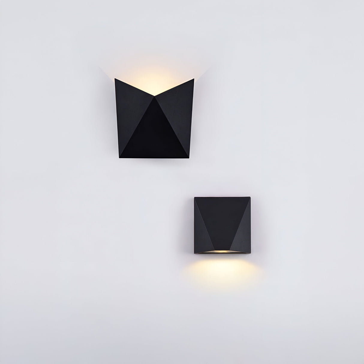 The Beekman Outdoor LED Wall Light 3000K - Black features two minimalist sconces with angular black designs. The top sconce directs light upward, the bottom downward. Mounted on a white wall, these IP54-rated lights provide reliable outdoor performance.