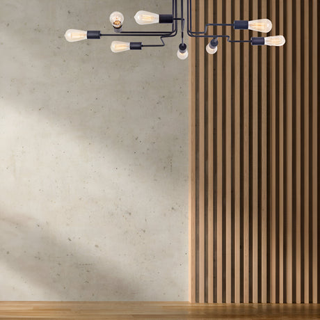 A minimalist room features the Gilbert 8 Light Semi-Flush - Black chandelier with exposed bulbs, against a concrete-textured wall on the left and a wooden slat design on the right. The light wood floor completes the modern industrial aesthetic.