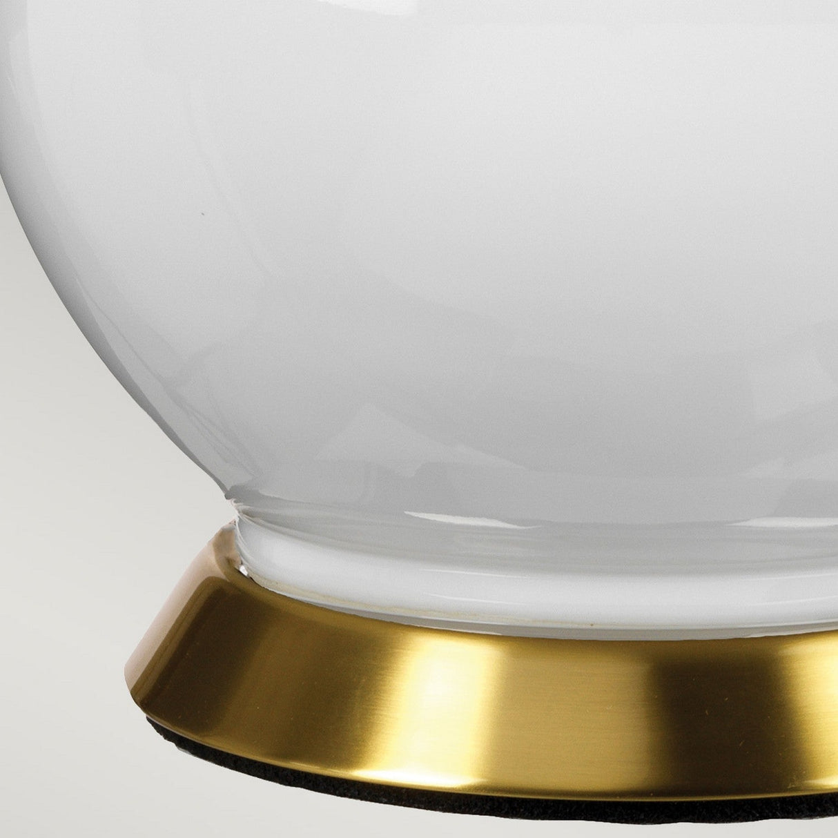 Close-up of the Isla 1 Light Table Light in white and pink, featuring a reflective glass orb with a metallic gold base and a ceramic foundation. The glossy surface contrasts with the matte finish of the base and soft pink shade, creating an elegant aesthetic.