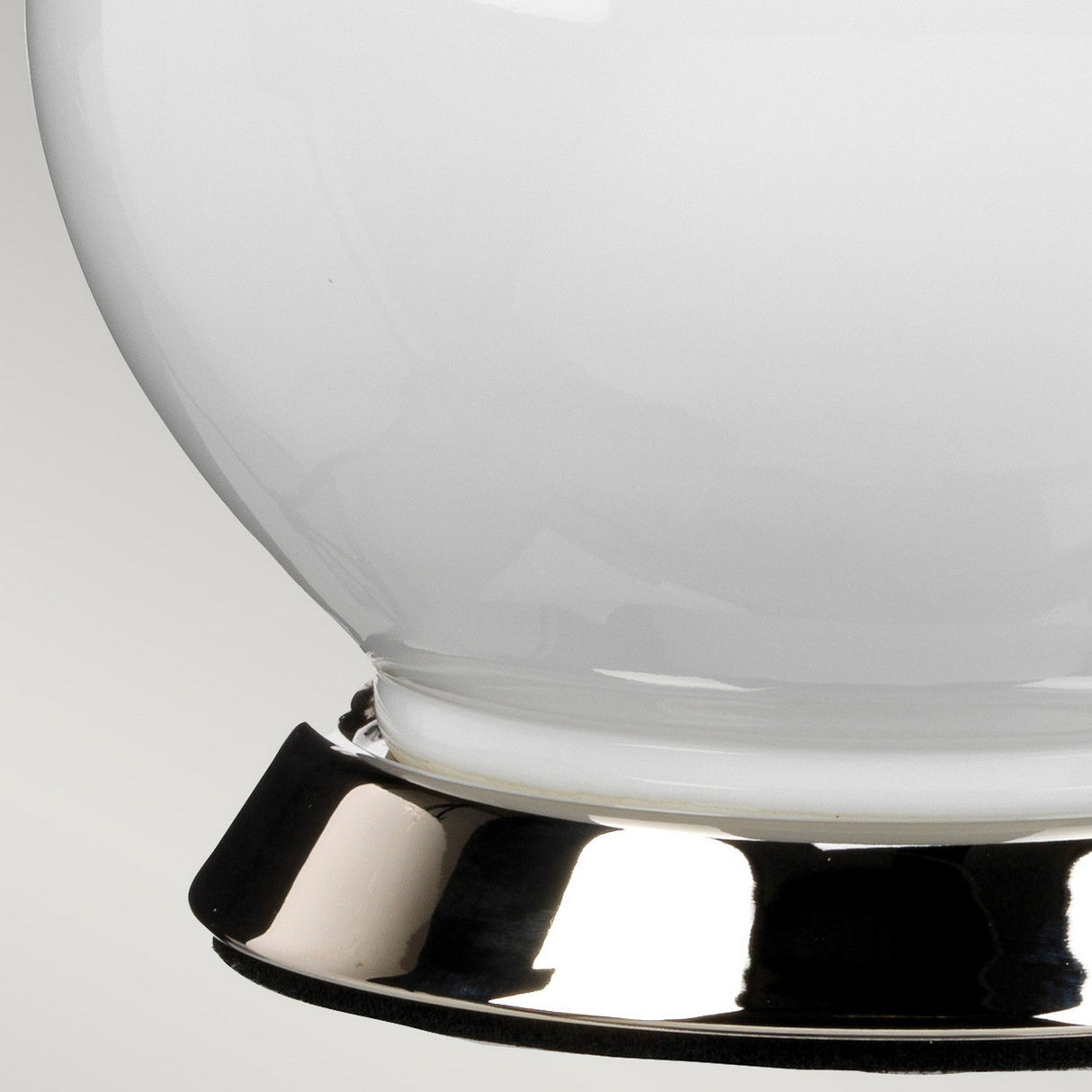 Close-up of the Isla 1 Light Table Light in white and yellow, featuring a shiny white ceramic vase with a reflective metallic base. The soft gradient of light gray in the background highlights the vase's smooth, glossy surface.