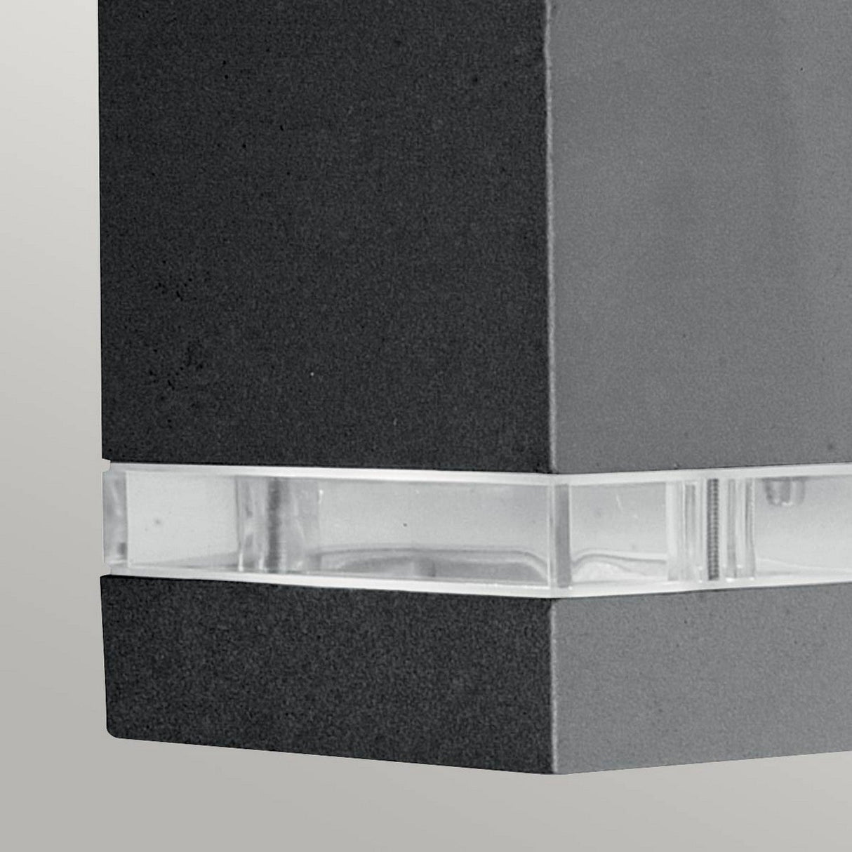 Close-up of the Jannik 2 Light Outdoor LED Wall Light - Graphite, featuring its sleek rectangular design with a graphite finish and an energy-efficient clear strip in the middle, beautifully accented against a light gray background.