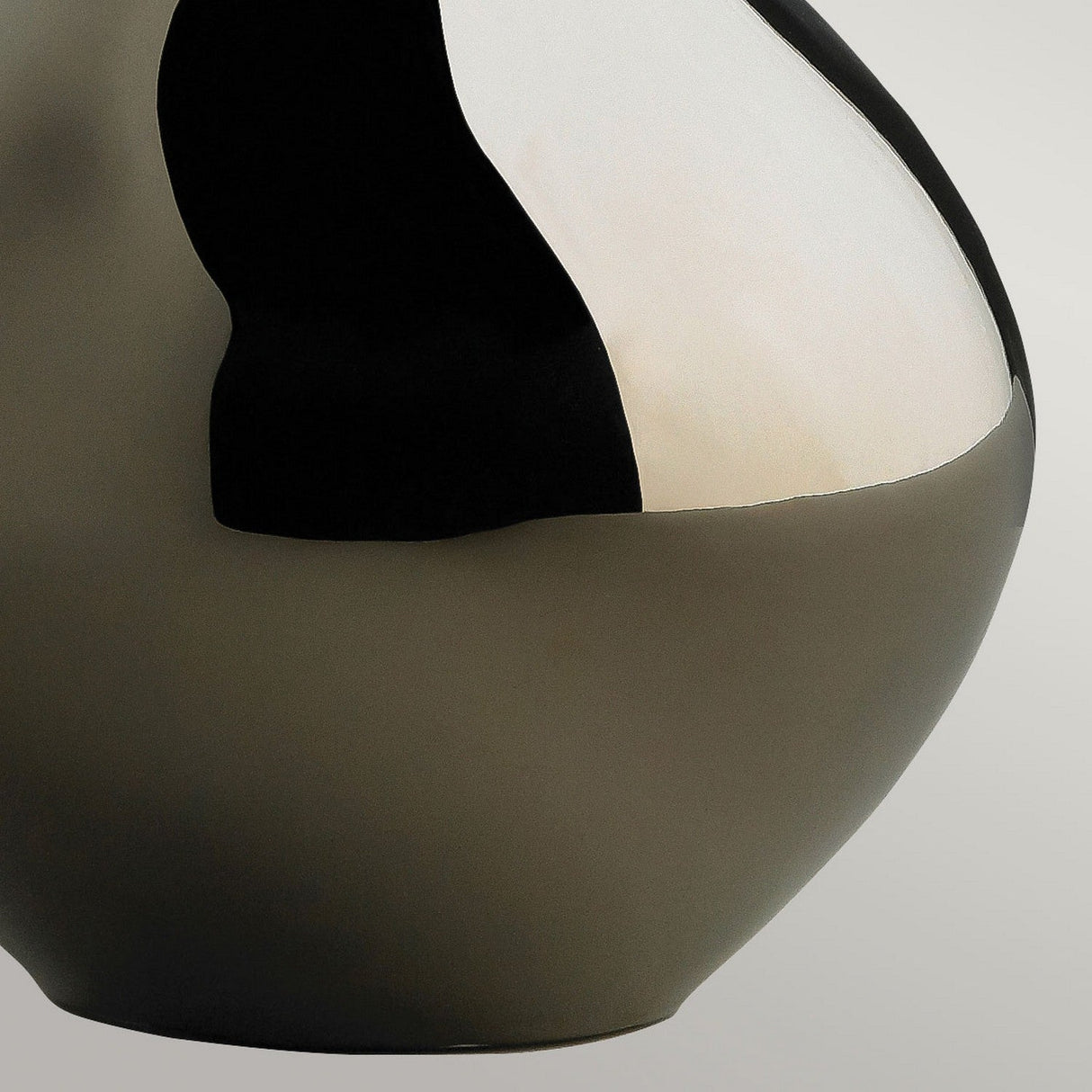 Close-up of the Job 1 Light Table Lamp, featuring a uniquely shaped ceramic base with a smooth surface and a wavy, abstract design in bronze metallic and brown. The lamp's curvy body creates a sleek and modern aesthetic against a neutral background, perfectly complemented by a faux silk shade.