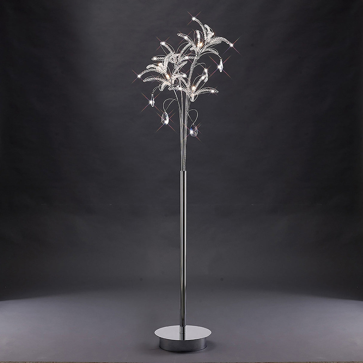 The Kenzo 6 Light Crystal Floor Lamp features a polished chrome base and tree-like, crystal-accented branches, creating a modern and elegant look that stands out beautifully against dark backgrounds.