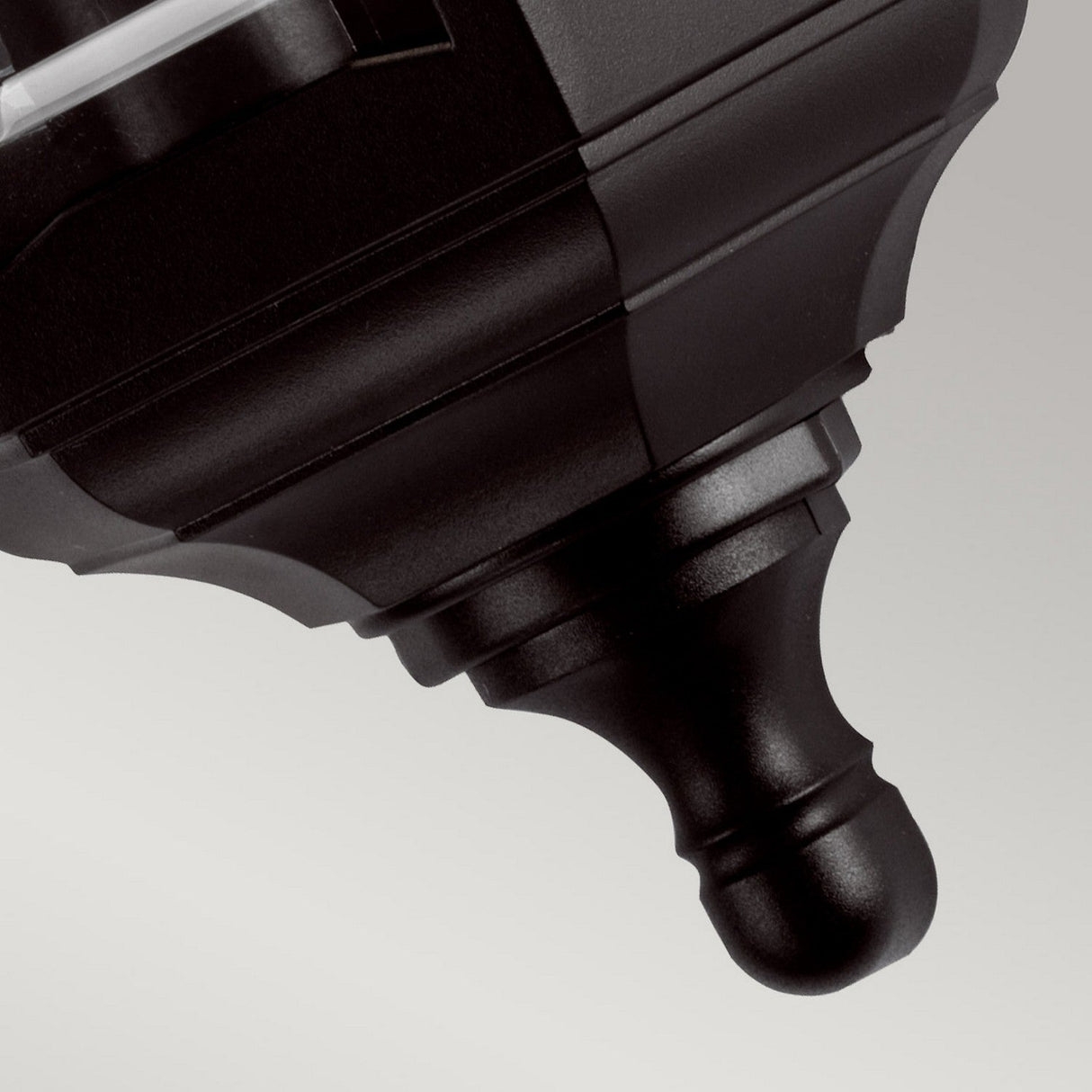 A close-up of the textured black nozzle of the Kinsale-1 1 Light Outdoor Wall Light - Black, set against a plain, light-colored background.