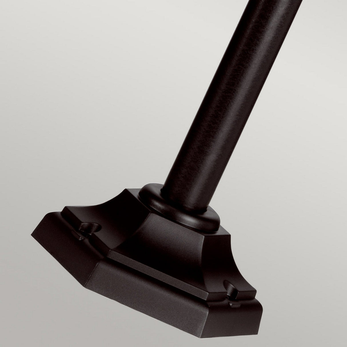 Close-up of the Kinsale 1 Light Lamp Post in black, featuring a sleek, dark metal rod ending in a decorative angular base with beveled edges and bolt details. Ideal for outdoor illumination, this corrosion-proof lamp post stands out against the plain, light gray background.