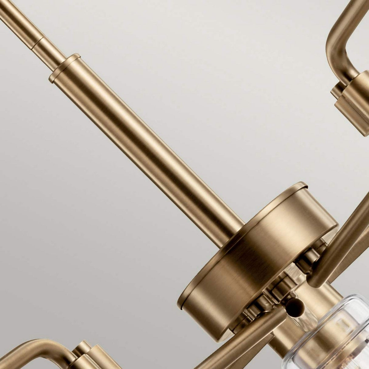 Close-up of the Aivian 5 Light Chandelier in a weathered brass finish, emphasizing its central structure with multiple arms extending outward, which showcases a sleek and industrial style.