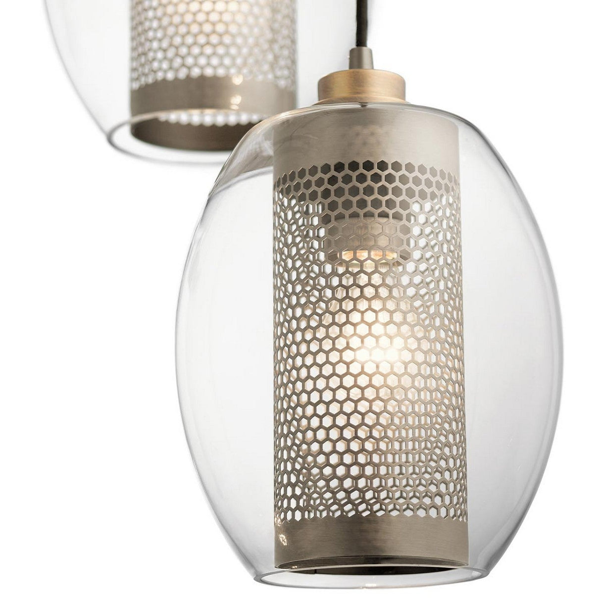 A close-up of two Asher 1 Light Mini Pendants in silver showcases their transparent glass outer shells and perforated metal inner shades, each containing a glowing bulb. These lights embody a sleek, contemporary style against a plain white background.