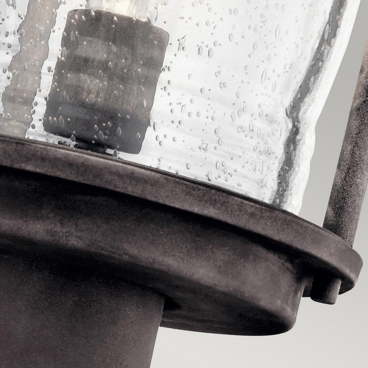 Close-up of the Ashland Bay Outdoor 1 Light Medium Pedestal Lantern in weathered zinc finish, featuring a vintage-style design with a glass cover adorned with raindrops. The rustic charm of the metal base complements the neutral background, while an LED Edison-style bulb glows inside for that timeless touch.