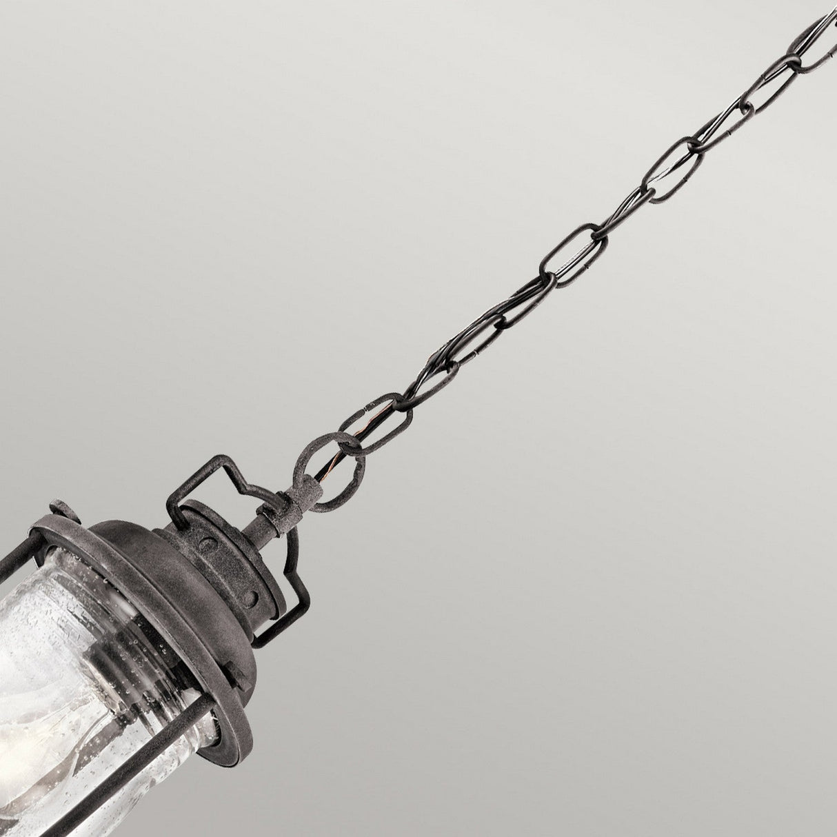 The Ashland Bay Outdoor 1 Light Small Chain Lantern in weathered zinc metal features a glass cover, LED Edison-style bulbs, and is suspended by a linked chain against a neutral background.