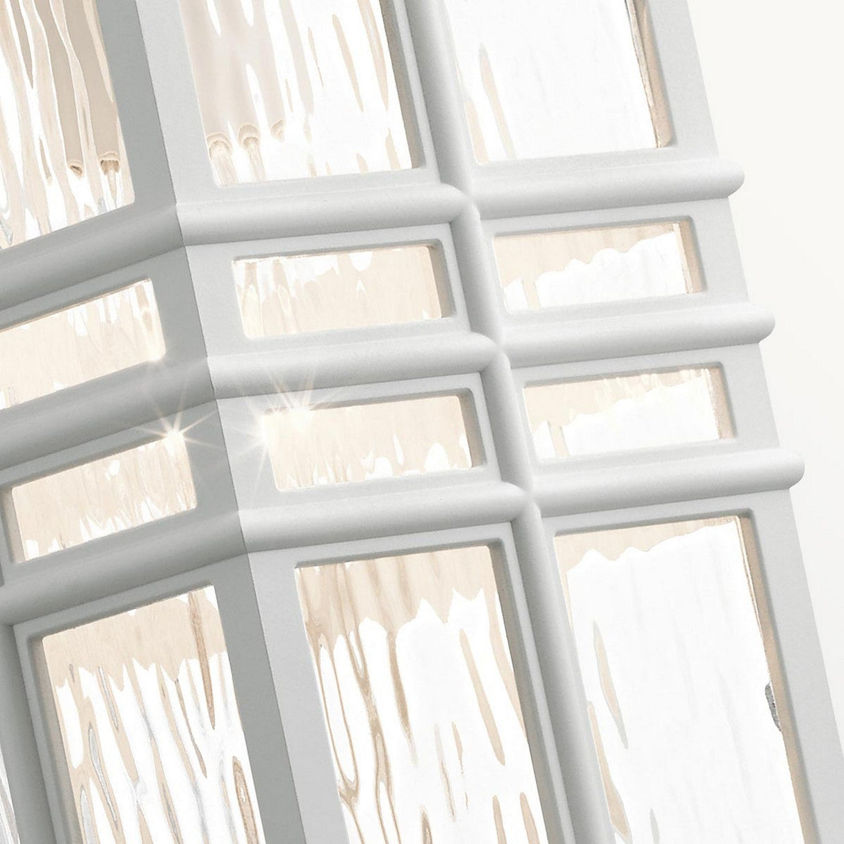 A close-up of a modern architectural structure, featuring white grid-like frames and reflective glass panes, mirrors the clean lines found in craftsman design. Sunlight interacts with these elements to produce brilliant reflections, much like the sleek and minimalist aesthetic of the elegantly crafted Beacon Square Outdoor 1 Light Medium Wall Lantern in White.