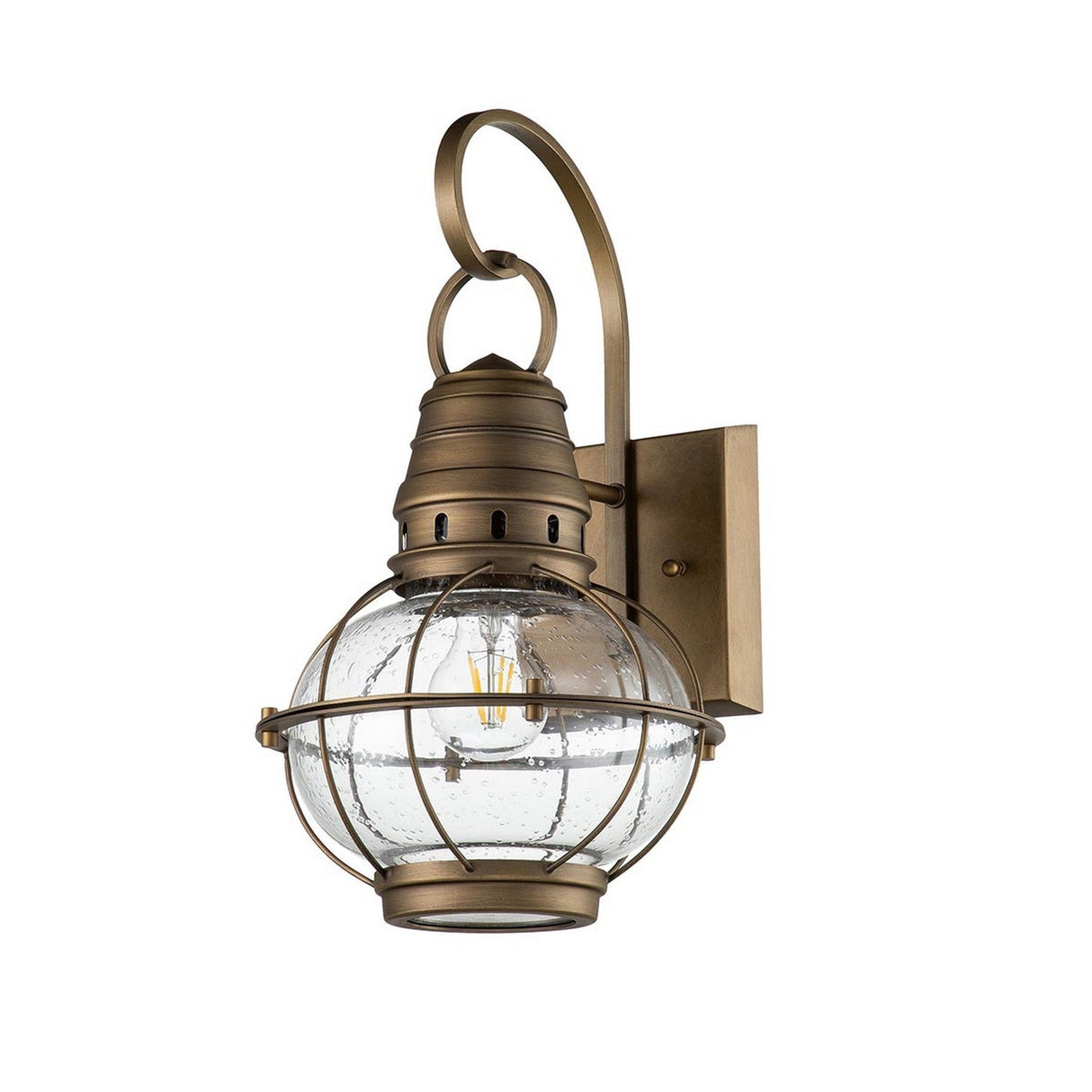 Introducing the Bridgepoint Outdoor 1 Light Medium Wall Lantern in Natural Brass. This nautical-style fixture showcases a round, clear glass globe encased in a metal cage design. Its rustic, vintage appeal is highlighted by a curved arm connecting to a square wall mount, providing timeless elegance with its natural brass finish.