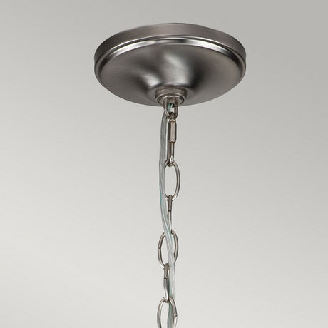 Close-up view of the Capitol Hill 12 Light Chandelier in brushed nickel, featuring a round base and a chain for suspension, set against a neutral gray backdrop.