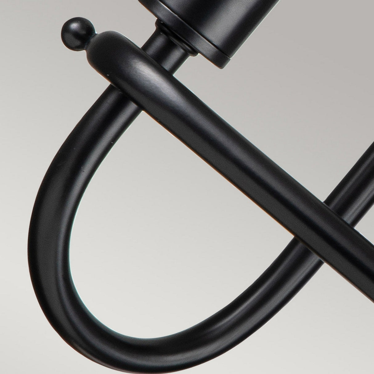 Close-up of the Capitol Hill 2 Light Wall Light - Black, featuring a sleek and curved design that highlights its ambient lighting and modern, minimalist aesthetics against a light gray background.