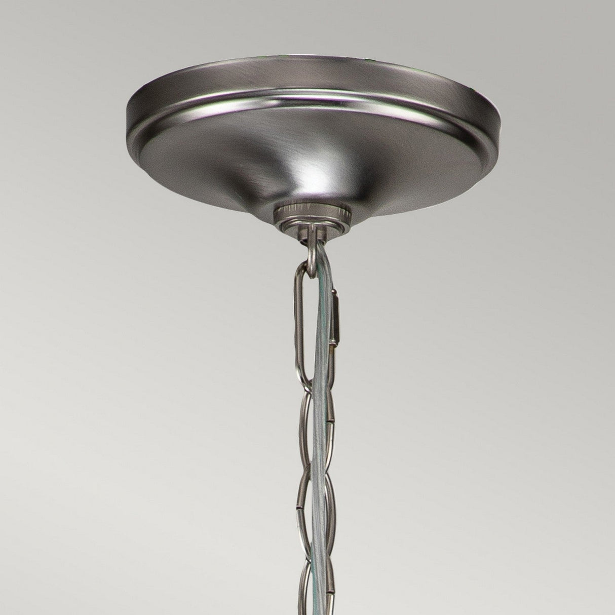 Close-up of the Capitol Hill 6 Light Chandelier in brushed nickel, featuring a chain hanging down, set against a plain light gray background. This elegant chandelier is designed to enhance ambient lighting in any room.