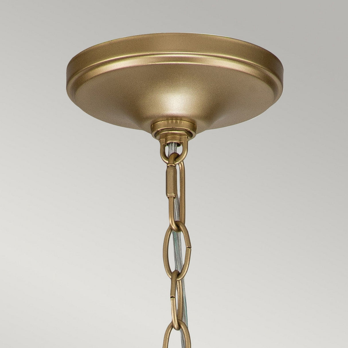 Against a plain background, the Capitol Hill 6 Light Chandelier - Natural Brass exudes elegance with its gold ceiling canopy and decorative chain extending downward, featuring six brilliant lights.
