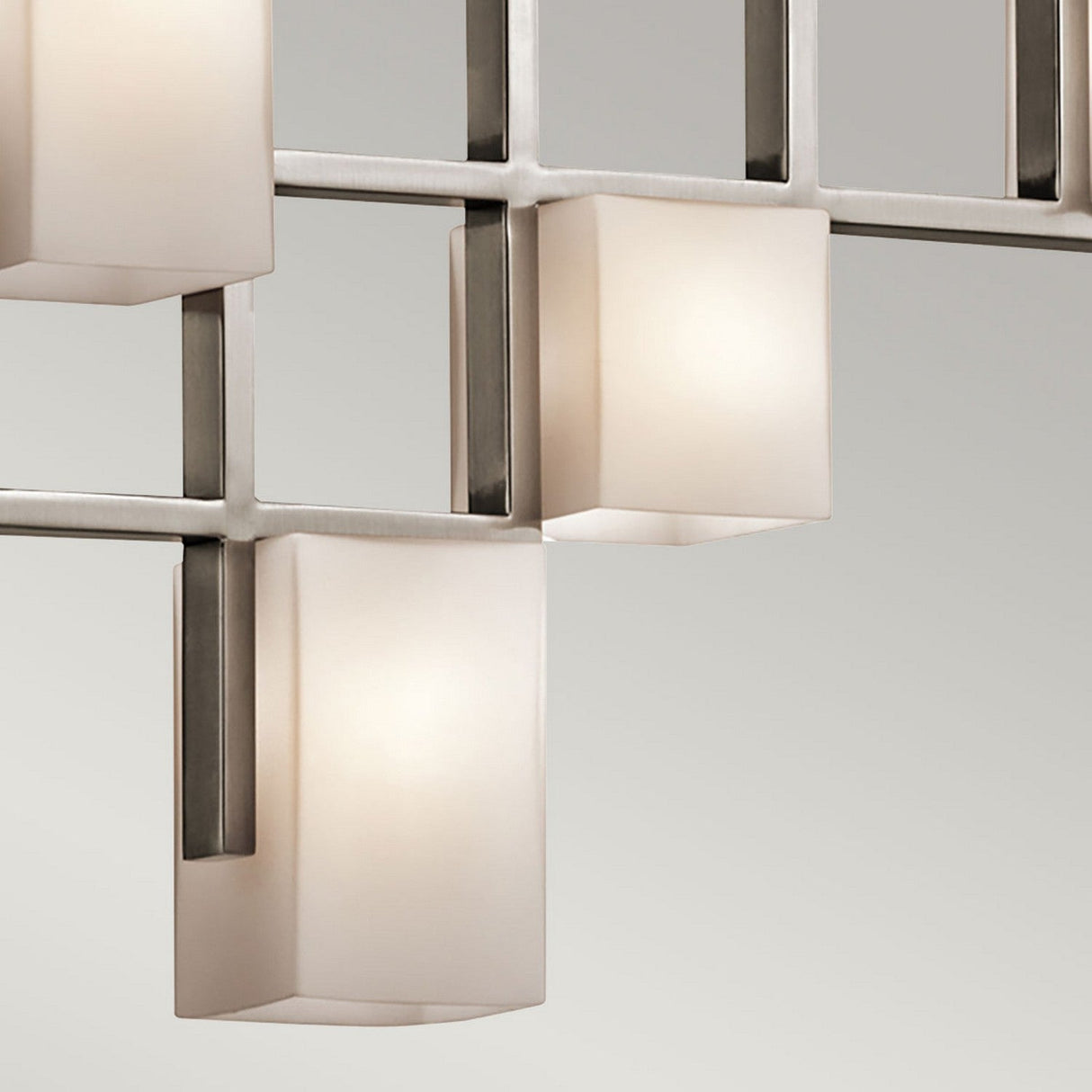 Close-up of the City Lights 7 Light Linear Chandelier in silver, featuring rectangular frosted glass shades mounted on a sleek metallic grid structure. The LED lights highlight its clean lines, providing a minimalist aesthetic that perfectly complements any modern decor against a neutral background.