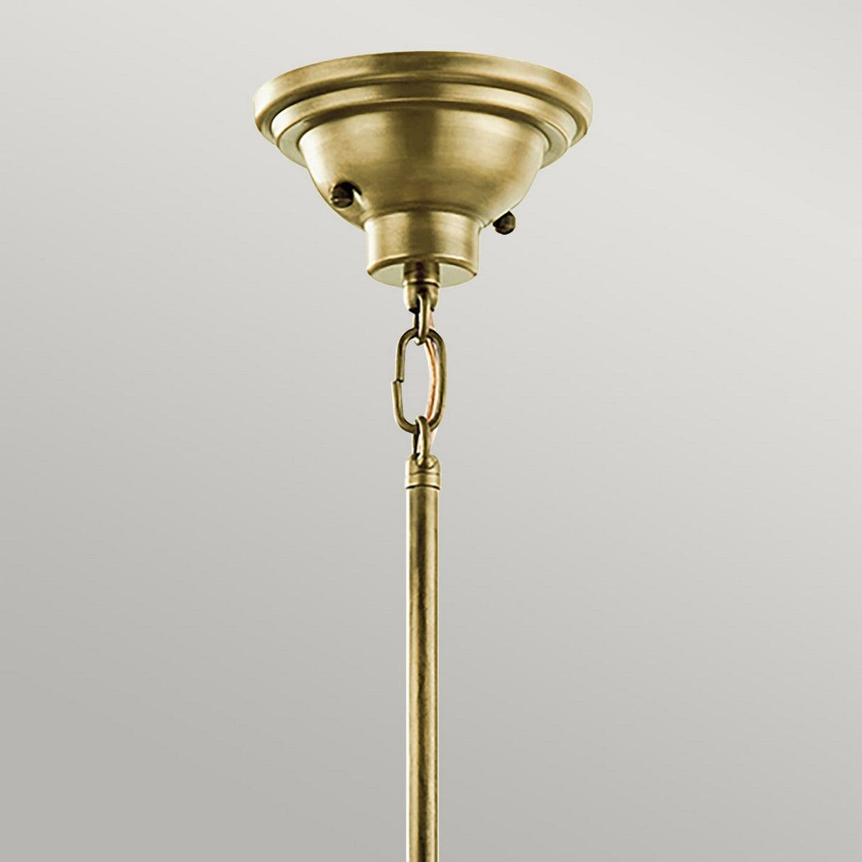 A close-up shot showcases the Cobson 1 Light Duo-Mount Pendant/Semi-Flush in natural brass, highlighting its vintage-inspired design with an antique dome-shaped base and a metal rod elegantly hanging from a chain link. This fixture exudes a retro-industrial lighting charm as it stands against a plain gray background.