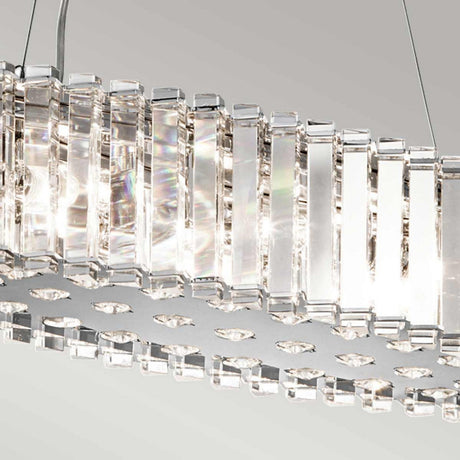 A close-up of the Crystal Skye 8 Light Island Chandelier in Chrome highlights its modern elegance with vertical rectangular crystal prisms that beautifully reflect light. Set against a soft, neutral background, its shimmering effect is enhanced while providing energy-efficient lighting for a sustainable touch.