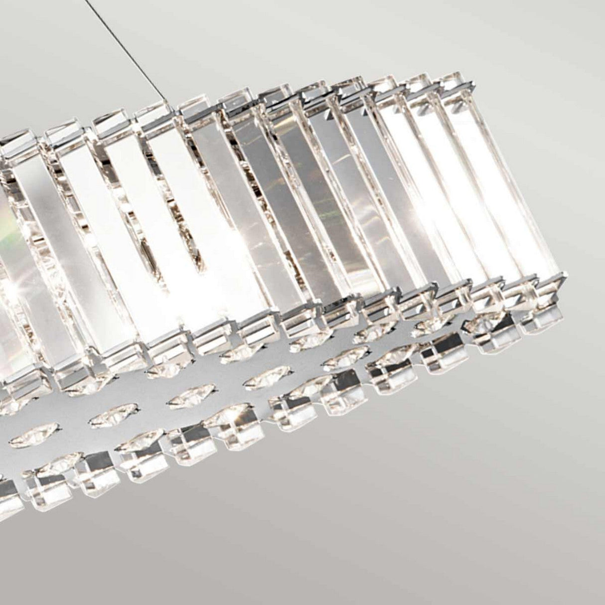 The Crystal Skye 8 Light Island Chandelier - Chrome radiates modern elegance with its multiple parallel glass strips hanging gracefully. Suspended from a wire against a light gray background, it provides energy-efficient lighting that casts a bright, elegant glow.