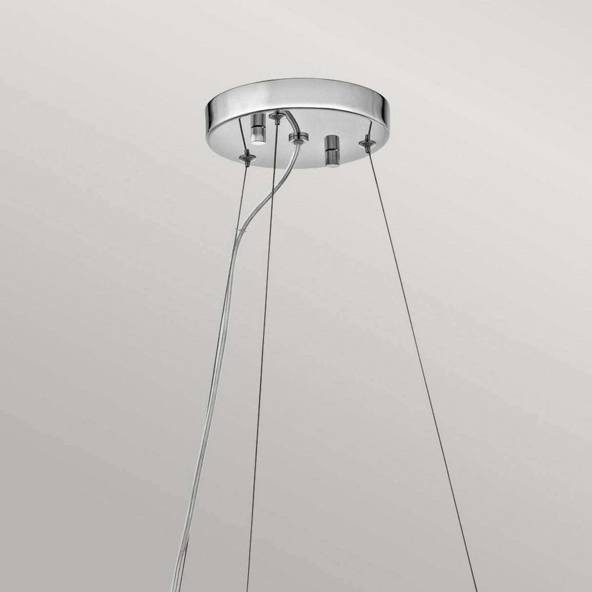 A contemporary ceiling light fixture with a circular chrome frame and LED compatibility, featuring several cables holding the lamp in place. Installed against a light gray background, this fixture bears similarities to the Crystal Skye 6 Light Chandelier - Chrome.