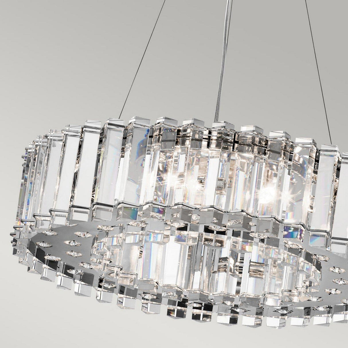 The Crystal Skye 8 Light Chandelier - Chrome, a luxurious lighting fixture, elegantly graces a neutral background. Its multiple vertical crystal prisms encircle the lights, producing a sparkling and sophisticated look.