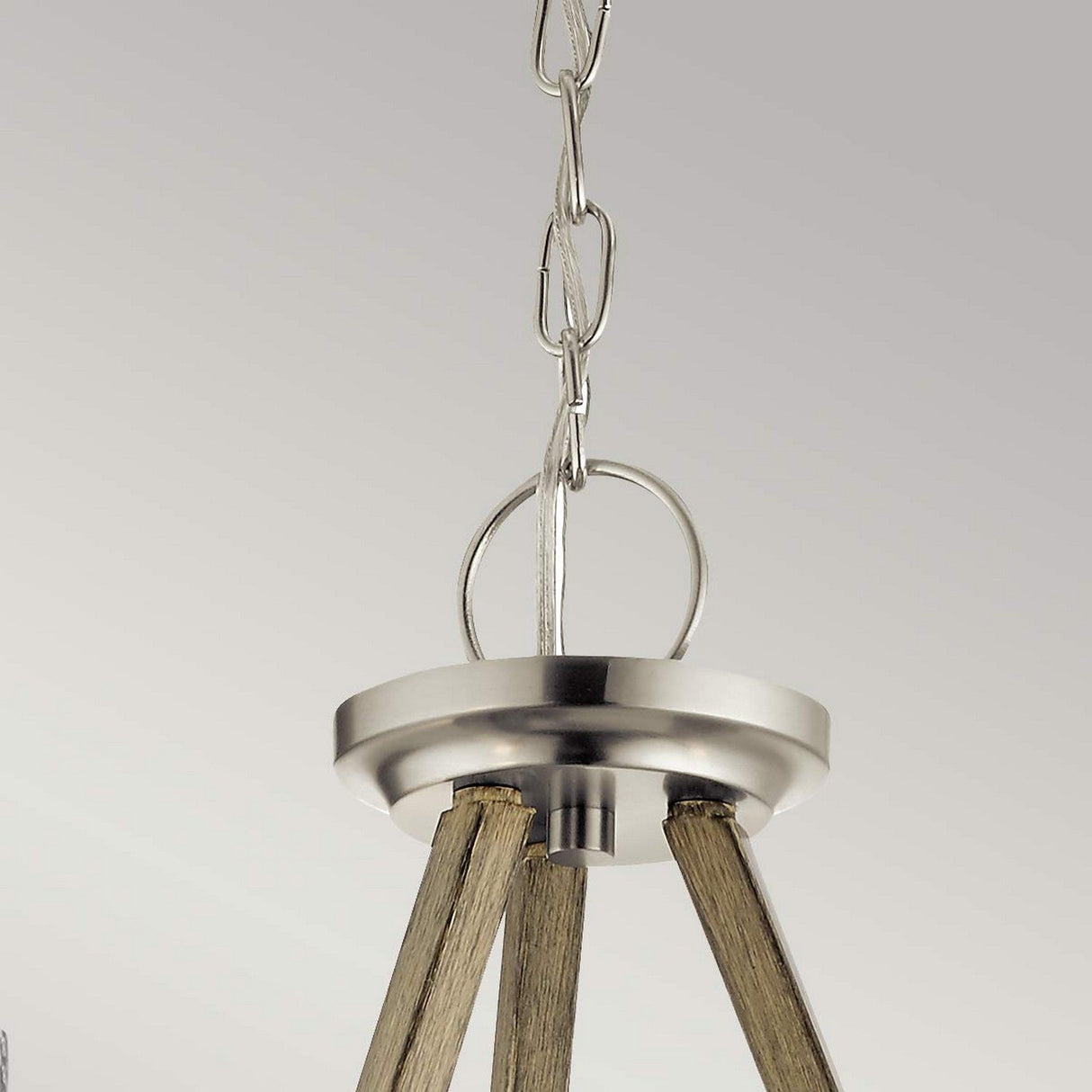 Close-up of the top part of the Deryn 3 Light Chandelier in antique grey, featuring a brushed metal finish and wooden accents. The chandelier is suspended by a metal chain, exuding rustic charm against a light gray background.