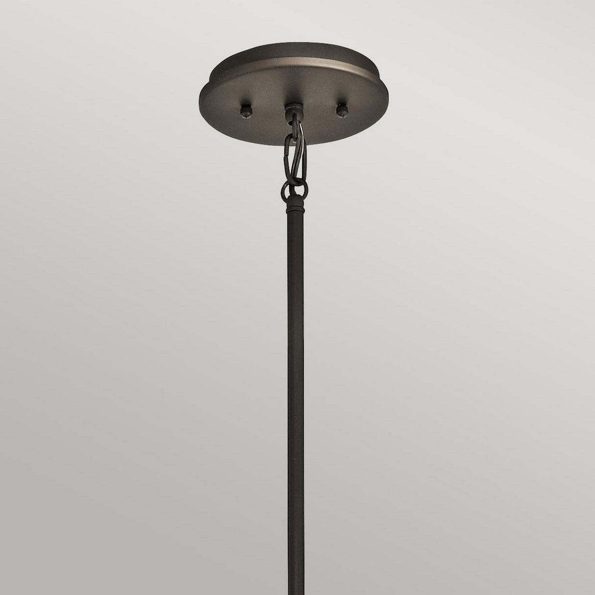 A close-up view of the Emory 4 Light Duo-Mount Chandelier in Olde Bronze displays a rod attached to a round base. The rod is secured with two screws and a loop, set against a plain gray background, highlighting the classic elegance of its design.