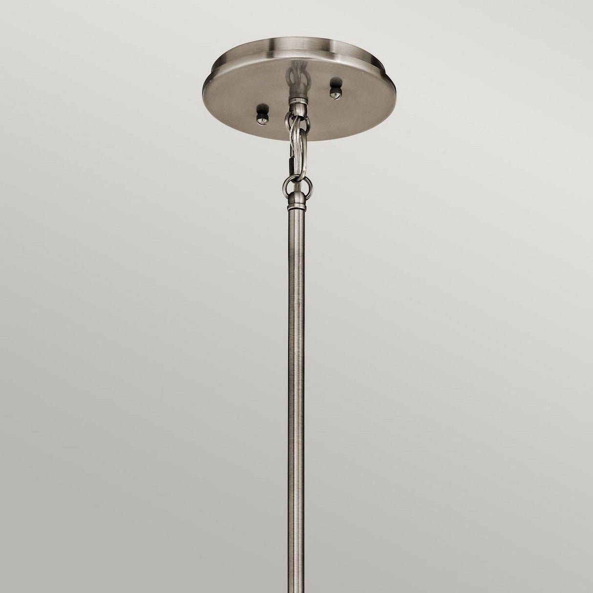 A close-up view of the Emory 3 Light Duo-Mount Pendant/Semi-Flush, showcasing its brushed nickel canopy and downrod with a sleek silver finish, set against a neutral gray background. The fixture's circular base and straight rod connected by chain links embody a contemporary look.