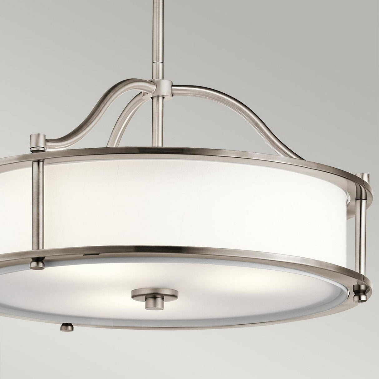 The Emory 3 Light Duo-Mount Pendant/Semi-Flush in Silver showcases a contemporary circular design with a fabric drum shade and elegant, curved metal supports. It is mounted on a central rod against a neutral gray background for a modern appeal.