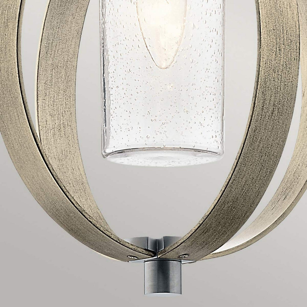 A close-up of the Grand Bank Outdoor 1 Light Pendant showcases its modern design, featuring a cylindrical glass shade adorned with subtle bubbles. Encased by elegantly curved metallic arms in an antique grey matte finish and complemented with brushed aluminium, this pendant offers a sleek and contemporary look, beautifully set against a neutral background.