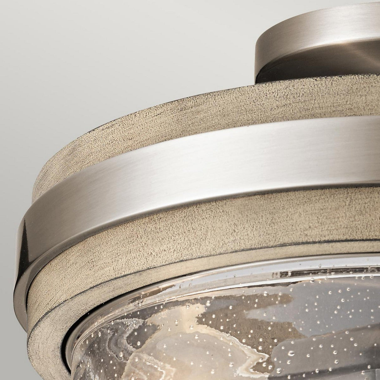 The Grand Bank 2 Light Semi Flush - Antique Grey features a modern metallic finish combined with the vintage industrial allure of a cylindrical design. Its textured, transparent glass cover, adorned with small bubbles, casts a sophisticated glow. Installed in a semi-flush style against an Antique Grey backdrop, this fixture exudes contemporary elegance.