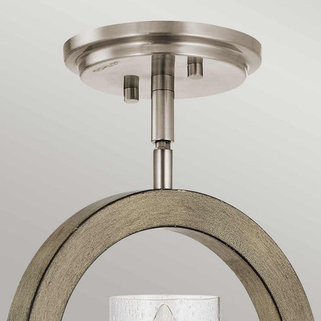 The Grand Bank 1 Light Wall Light in Antique Grey beautifully highlights its circular metallic base and curved wooden accent, seamlessly merging rustic charm with modern design. Its cylindrical frosted glass shade adds a sleek touch to the overall aesthetic.