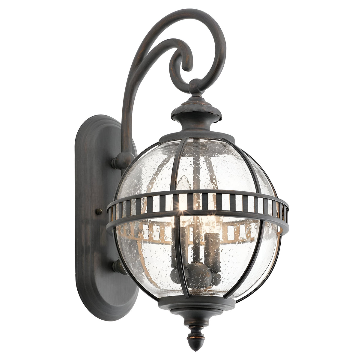 The Halleron Outdoor 2 Light Wall Lantern - Grey captures a Victorian-inspired charm with its spherical clear seeded glass shade and grey finish. The intricate metalwork includes an elegant scroll design on the arm, and the speckled texture of the glass artfully highlights the bulb within.