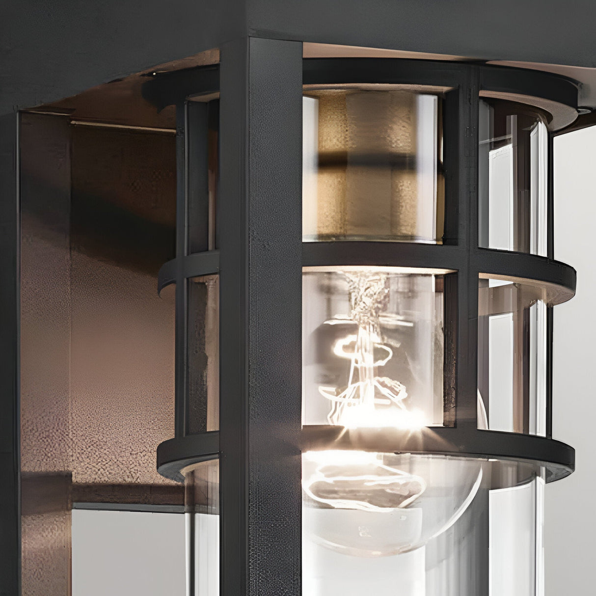 Close-up of the Hone Coastal 1 Light Small Outdoor Wall Lantern in black, showcasing a weather-resistant metal frame, clear glass, and geometric design—ideal for modern coastal lighting.