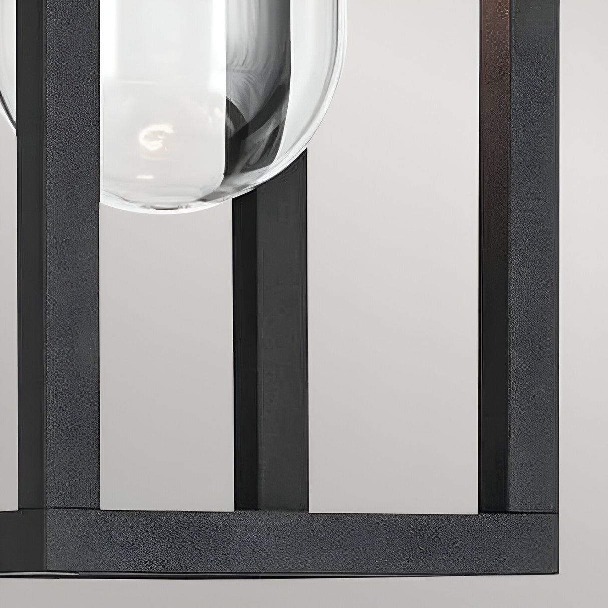 Close-up of the Hone Coastal 1 Light Small Outdoor Wall Lantern in black, showcasing its clear glass shade within a sleek, weather-resistant rectangular metal frame against a plain background.