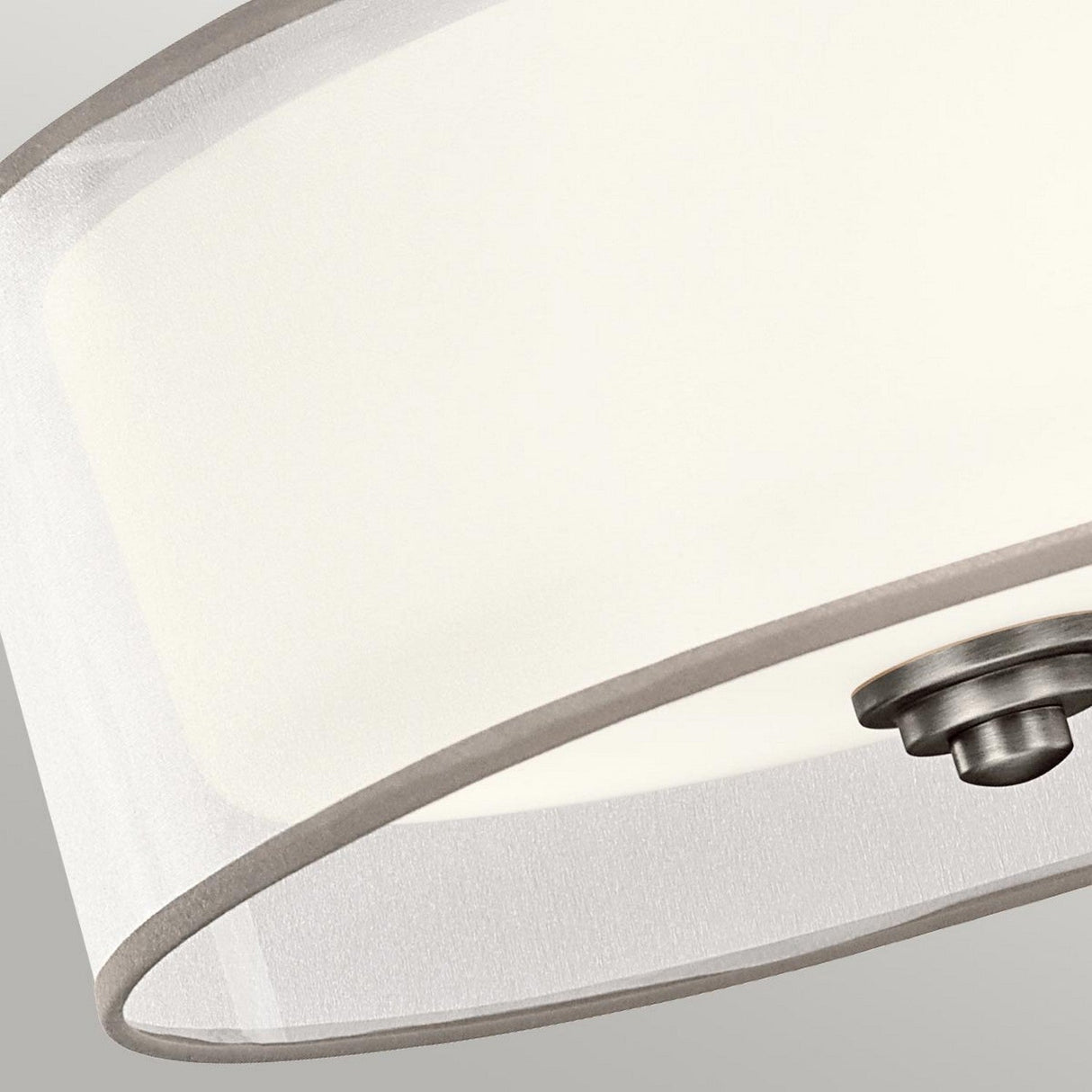 Close-up of the Lacey 3 Light Small Semi Flush - Silver ceiling light fixture, featuring a round, translucent white shade and a polished silver finish. The image emphasizes the lower part, showcasing its minimalistic and sleek design with a layered glow against a neutral background.