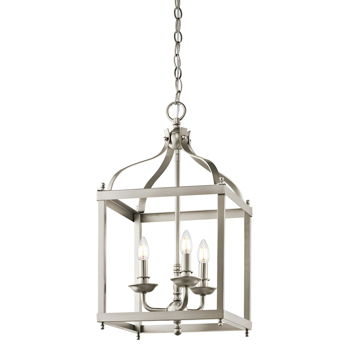 The Larkin 3 Light Medium Chandelier in brushed nickel showcases three candle-shaped light bulbs, elegantly suspended within a geometric, open cage design. Hanging gracefully by a chain, it provides a contemporary twist to traditional lantern-style lighting.